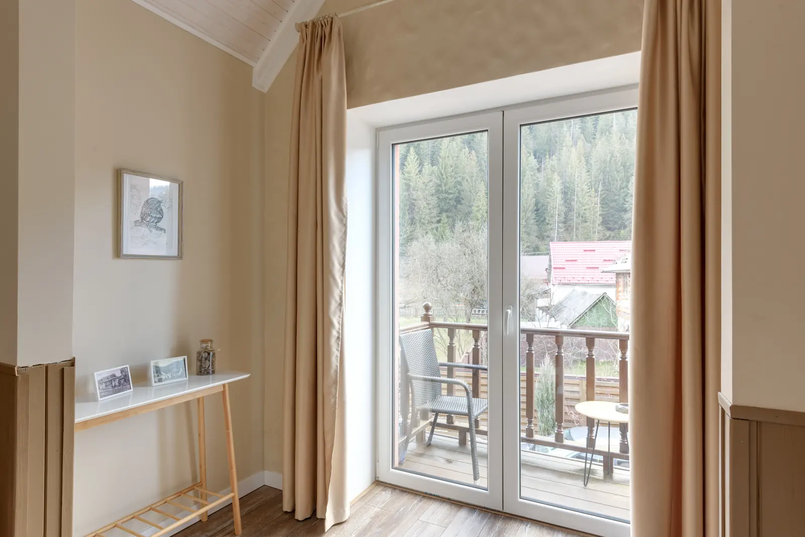 Weiße verglaste Balkontür mit Blick auf einen Balkon und eine bewaldete Berglandschaft